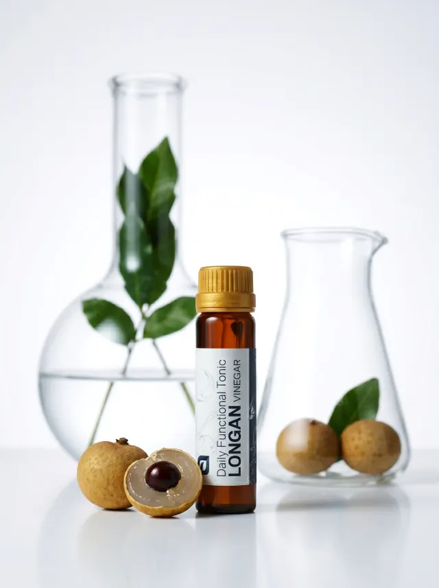 Longan Vinegar tonic beside laboratory flasks and fresh longan